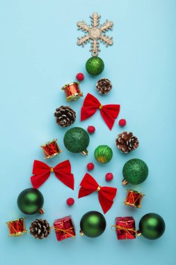 Mavi arka planda süslemek için küçük parçalardan oluşan bir Noel ağacı. Üst görünüm