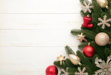 Noel çerçevesi - kırmızı ve altın takıları olan ağaç dalları, yıldızlar, beyaz arka planda kar taneleri. Üst görünüm