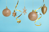 Zlaté vánoční koule s stuhou na modrém pozadí s kopírovacím prostorem. Nový rok2022. Horní pohled
