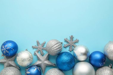 Mavi ve gümüş renkli Noel topları mavi arka planda. Üst görünüm.