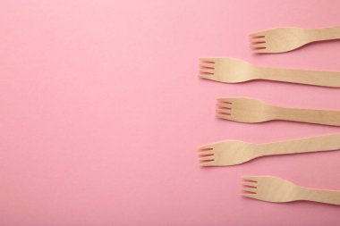 Pembe arka planda ahşap çatal. Üst görünüm.