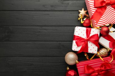 Noel süslemeleri ve hediye kutuları siyah arka plan üzerine arka plan. Üstten görünüm