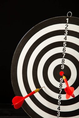 Siyah arka planda kırmızı okları olan dart tahtası. Üst görünüm.
