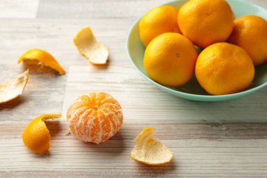 Ahşap arka planda naneli kase üzerinde taze mandalina meyvesi. Üst görünüm.