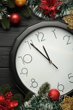 Siyah ahşap arka planda noel süslemesi olan Noel saati. Mutlu yıllar konsepti.