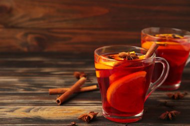 Tarçınlı sıcak şarap ve kahverengi arka planda anason yıldızları. Üst görünüm.