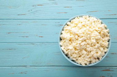 Kahvaltı için süzme peynir mavi ahşap arka planda kasede. Üst görünüm