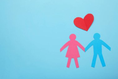 Kağıt ailesi ve kalbi mavi arka planda. Aşk ve aile kavramı. Üst görünüm