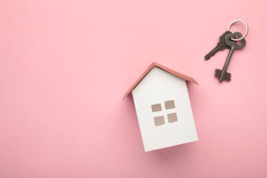 Kağıt ev ve anahtar pembe arka planda fotokopi alanı var. Üst görünüm