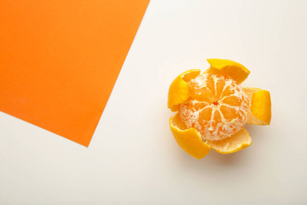 Fresh peeled mandarin orange on colorful background. Top view.