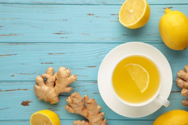 Mavi ahşap zemin üzerinde limonlu ve ballı zencefil çayı.