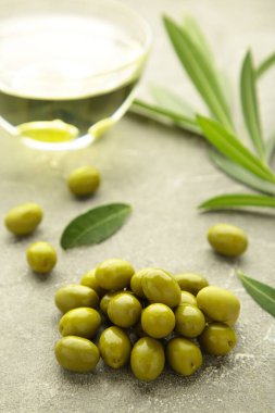 Gri arka planda yağlı zeytin. Dikey fotoğraf. Üst görünüm