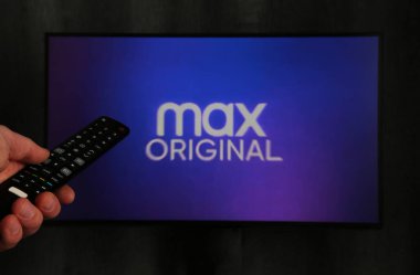 Nikolaev, Ukrayna - 20 Kasım 2021. TV kumandası tutan ve Max TV izleyen bir adam. HBO Max, WarnerMedia Direct aracılığıyla ATT 'nin sahip olduğu talep yayın servisi üzerine bir Amerikan abonelik videosu..