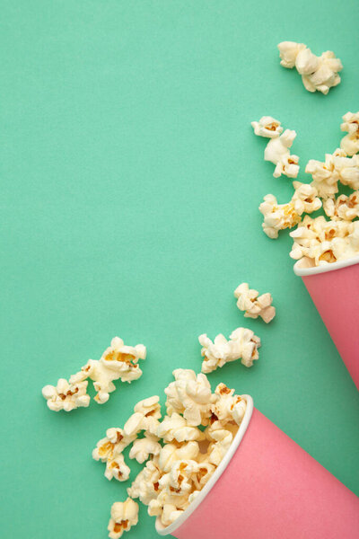 Popcorn in pink cups. Three cups of popcorn on mint background. Sweet popcorn. Top view