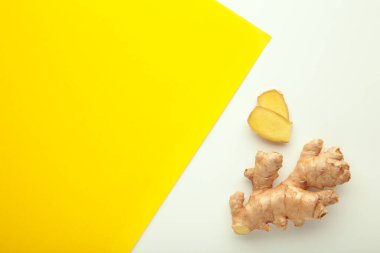 Beyaz ve sarı arka planda limon ve zencefil. Dikey fotoğraf. Üst görünüm