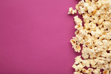 Pembe arka planda patlamış mısır ve fotokopi alanı. Üst görünüm