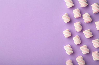 Mor arka planda beyaz ve pembe lokum. Pastel desenli yaratıcı desen. Çok az. Üst görünüm