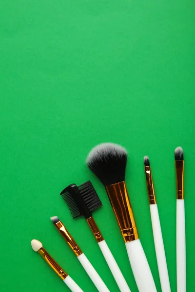 Set Pinceles Maquillaje Sobre Fondo Verde Vista Superior — Foto de Stock