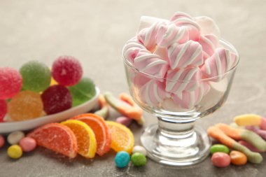 Renkli şekerler, gri arka planda lolipoplar ve jöle. Üst Manzara. Kopyalama alanı olan tatlılar