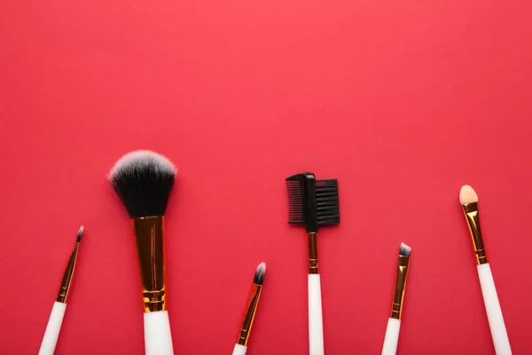 Set Pinceles Maquillaje Sobre Fondo Rojo Vista Superior — Foto de Stock