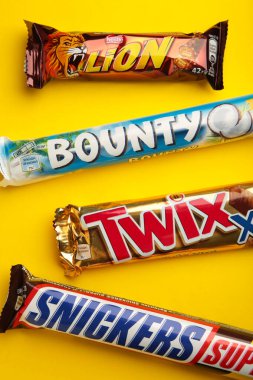 Sarı arka planda Snickers, Mars, Bounty ve Twix çikolataları. Üst Manzara. Nikolaev, Ukrayna - 19 Aralık 2021