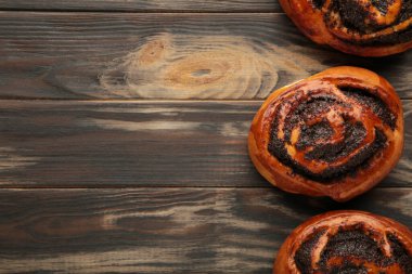 Kahverengi ahşap arka planda haşhaş tohumlu çörek..