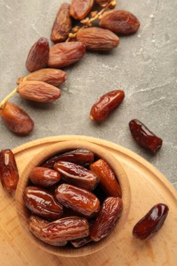 Gri ahşap arka planda kurumuş hurma kasesi. Gri tarihli şube.