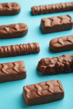 Mix of chocolate bars on blue background with copy space. Vertical photo.
