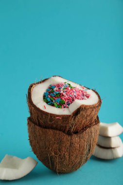 Mavi arka planda gökkuşağı parçacıkları olan hindistan cevizi. Yaz kavramı. Dikey fotoğraf