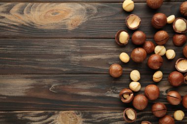 Kahverengi ahşap arka planda Macadamia fındıkları.