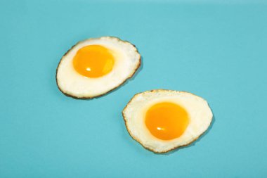 Mavi arka planda iki kusursuz kızarmış yumurta. Üst görünüm.