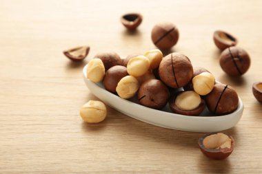 Bej arka planda soyulmuş macadamia fındıkları. Üst görünüm