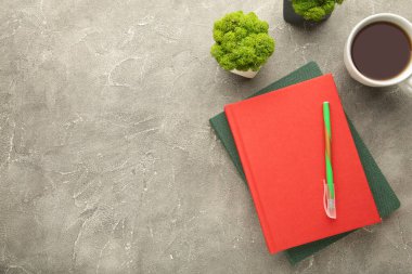 Gri arka planda kahve fincanı ve kalem olan kırmızı defter. Düz yatış, yaratıcı çalışma alanı ofisi. Kopyalama alanı ile işletme eğitimi kavramı. Üst görünüm