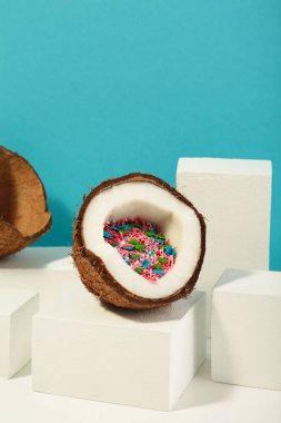 Mavi arka planda hindistan cevizi. Hindistan cevizinin yarısı serpiştirilmiş. Üst Manzara. Dikey fotoğraf