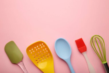 Pembe arka plan manzaralı farklı mutfak eşyaları. Yemek pişirme aletleri.