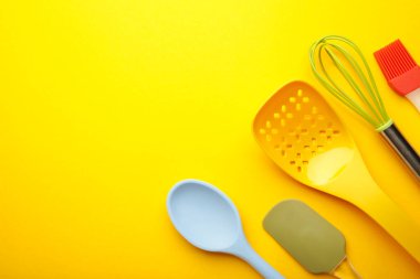Sarı arka plan manzaralı farklı mutfak eşyaları. Yemek pişirme aletleri.
