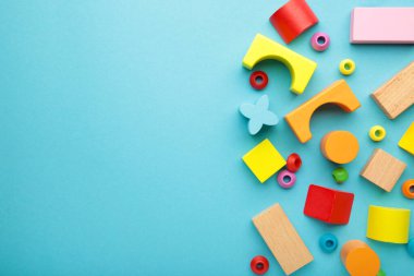 Çocukların inşaatçısının çok renkli blokları mavi arka planda yatıyor. Üst görünüm
