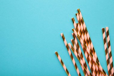 Açık mavi arka planda ve fotokopi alanı olan yaz kokteylleri için renkli pipetler içmek. Üst görünüm.