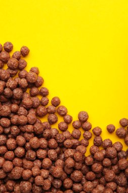 Sarı arka planda çikolatalı mısır gevreği. Üst görünüm.