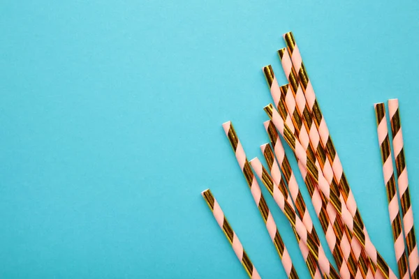 Açık mavi arka planda ve fotokopi alanı olan yaz kokteylleri için renkli pipetler içmek. Üst görünüm.