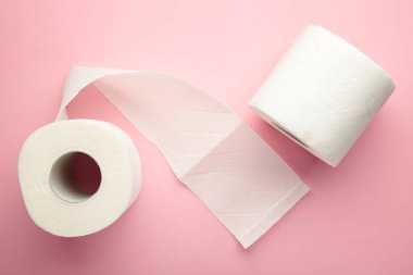 Pembe arka planda tuvalet kağıdı rulosu, üst görünüm.