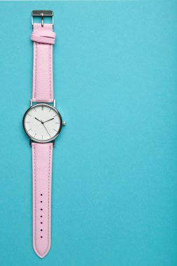Mavi arka planda, fotokopi alanı olan pembe kol saatleri. Üst görünüm