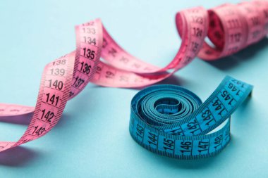 Mavi ve pembe, mavi arkaplan üzerinde metrik ölçekli plastik şerit. Üst Manzara. Diyet kavramı