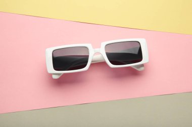 Pastel arka planda beyaz güneş gözlükleri, üst manzara, düz yatak, minimalist yaz konsepti, tatil.