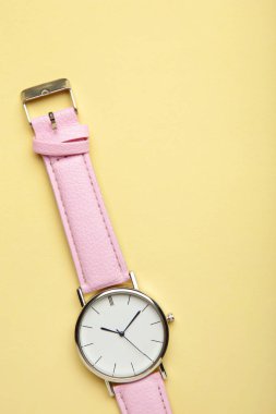 Bej arka planda pembe kol saatleri ve fotokopi alanı. Üst görünüm
