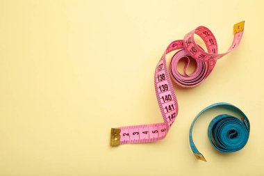 Bej arka planda metrik ölçekli mavi ve pembe plastik şerit. Üst Manzara. Diyet kavramı