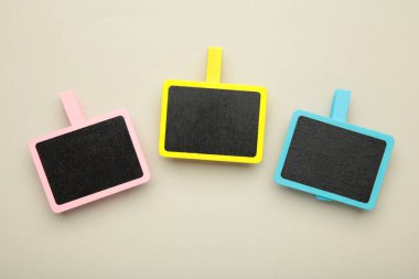 Gri arka plandaki mandallarda boş tahta tebeşir tabağı. Üst görünüm