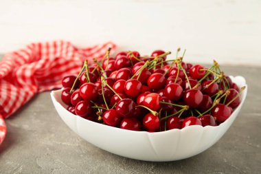 Kâsede taze kiraz ve arka planda peçete. Üst görünüm