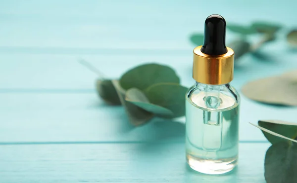 Eucalyptus Essential Oil Bottle Green Leaves Blue Background Top View — Stockfoto