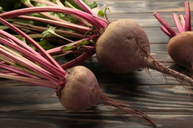 Kahverengi arka planda yeşil yapraklı kırmızı pancar. Üst görünüm.